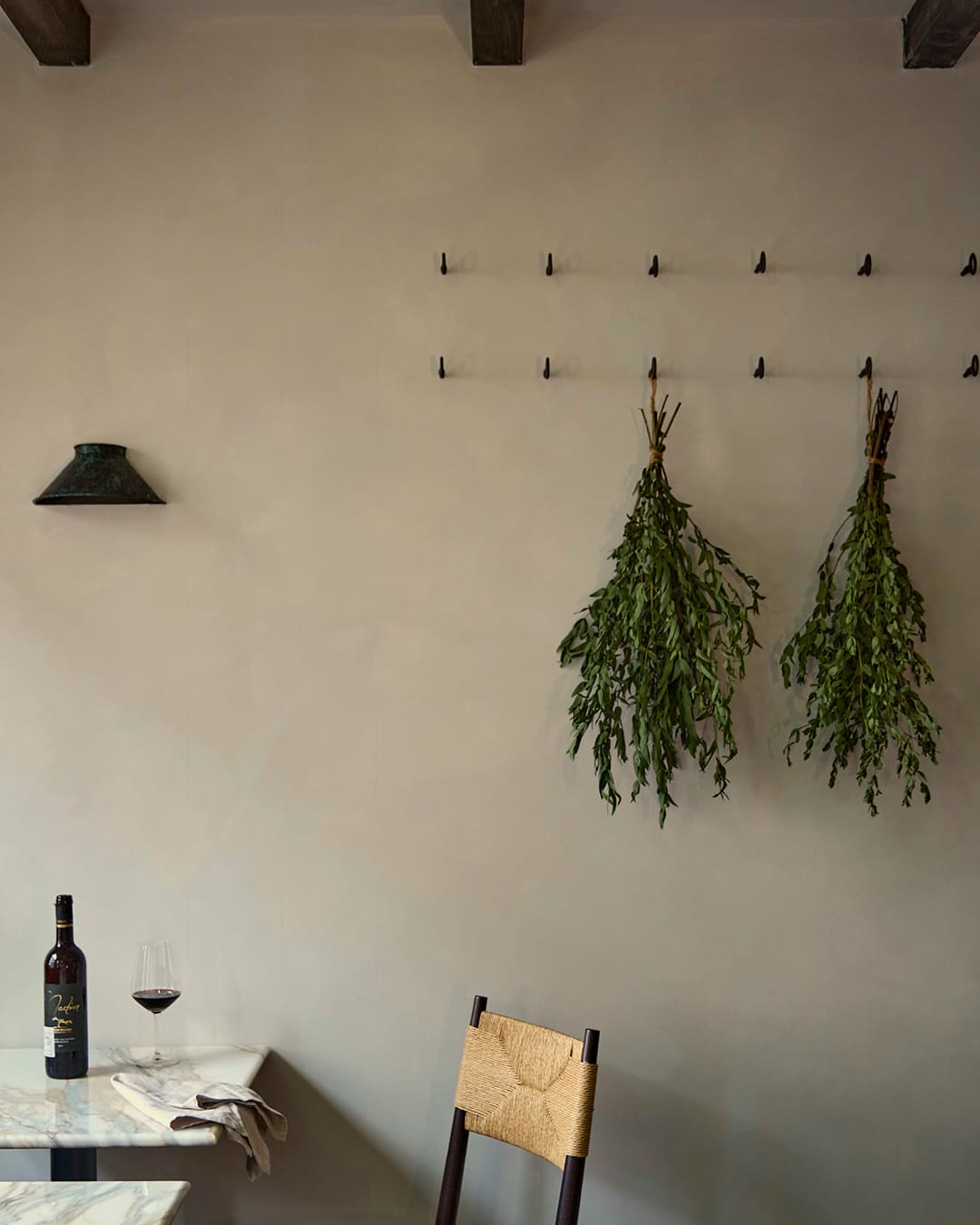 Natural light and a glass of wine beneath exposed beams at Akub in Notting Hill