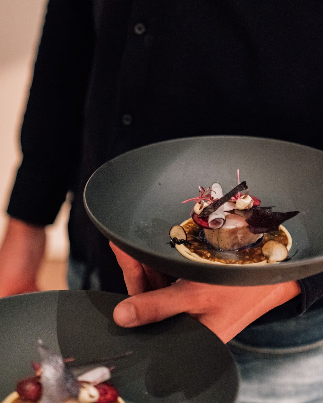 A fish dish served on a grey bowl at Concors restaurant in Utrecht.