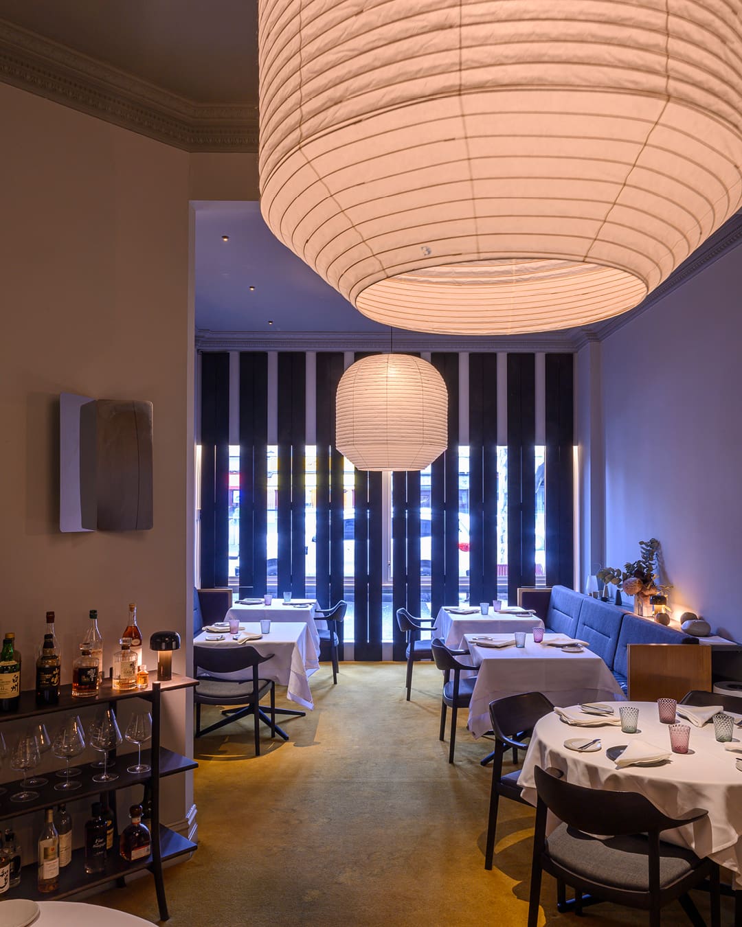 Paper lanterns and tables topped with white table cloths decorate the space at Kazuki's in Carlton