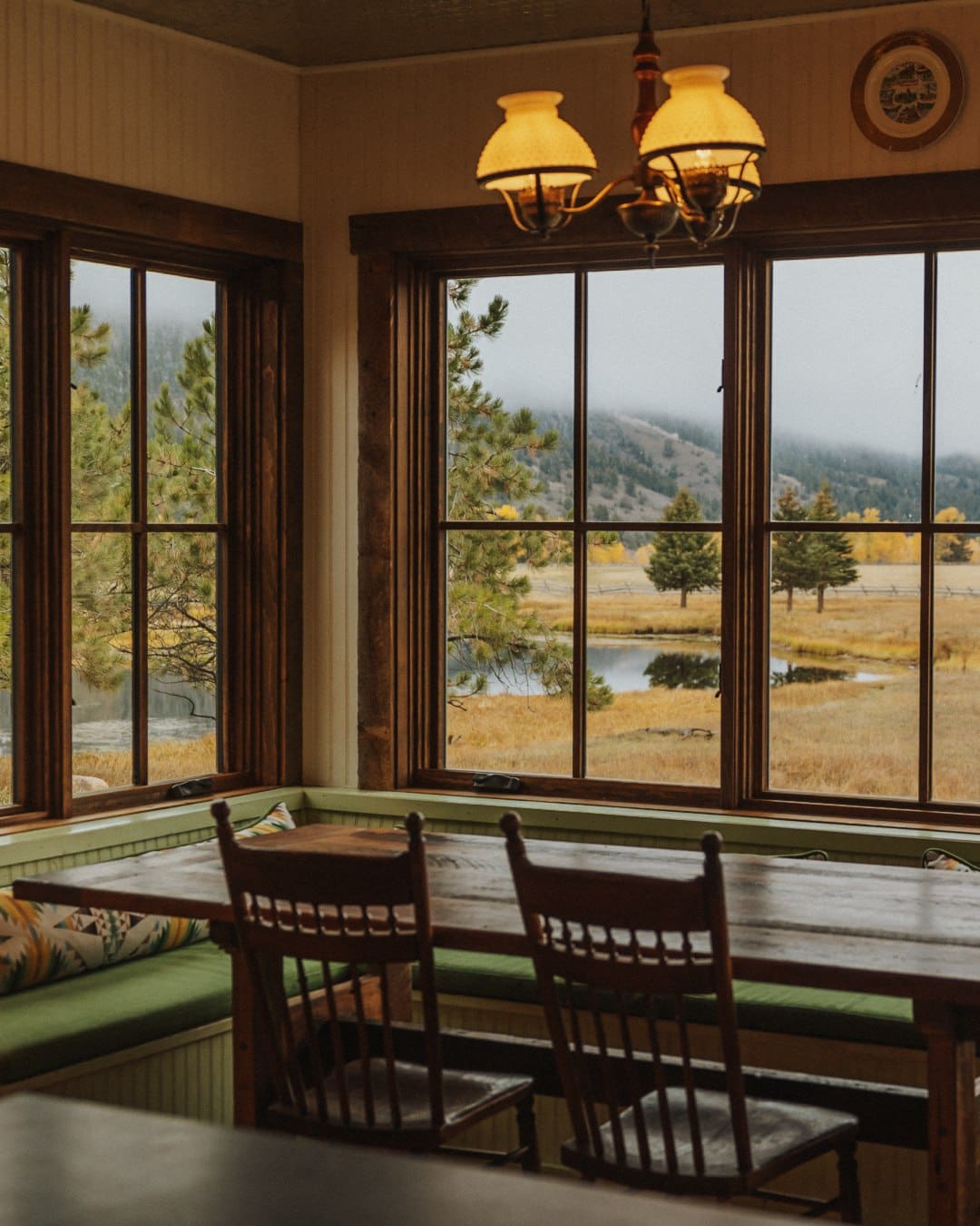 Wilderness view through the restaurant window at A women on a horse at The Ranch at Rock Creek in Montana