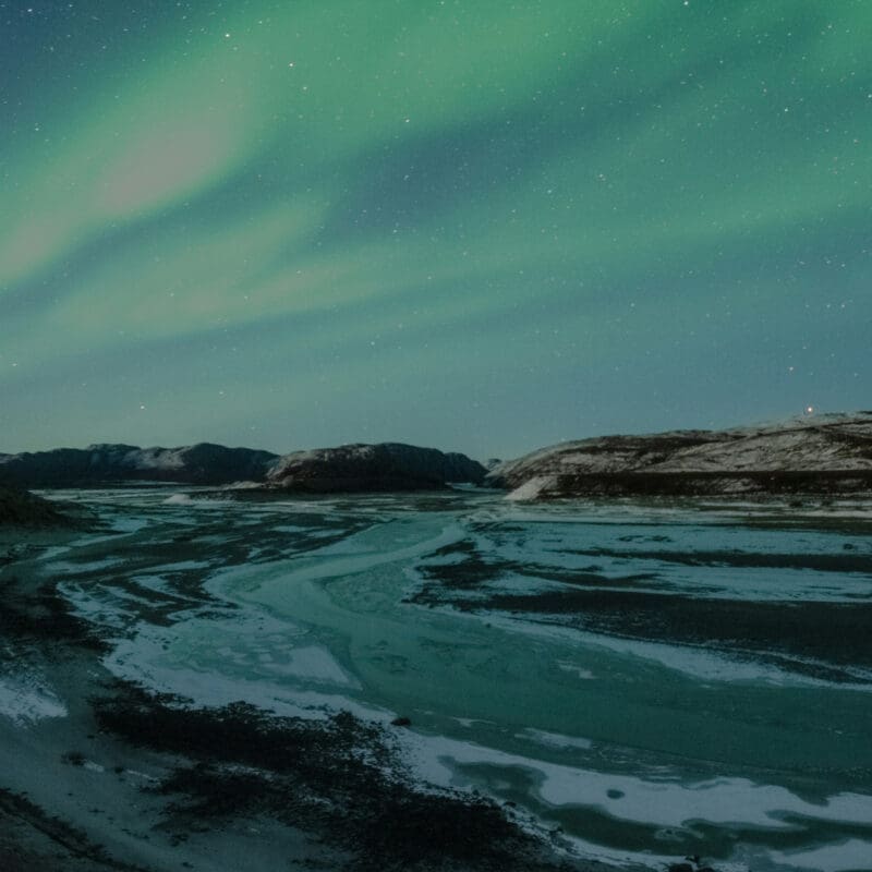 A stunning display of the Northern Lights seen above an icy beach in Kangerlussuaq in Greenland