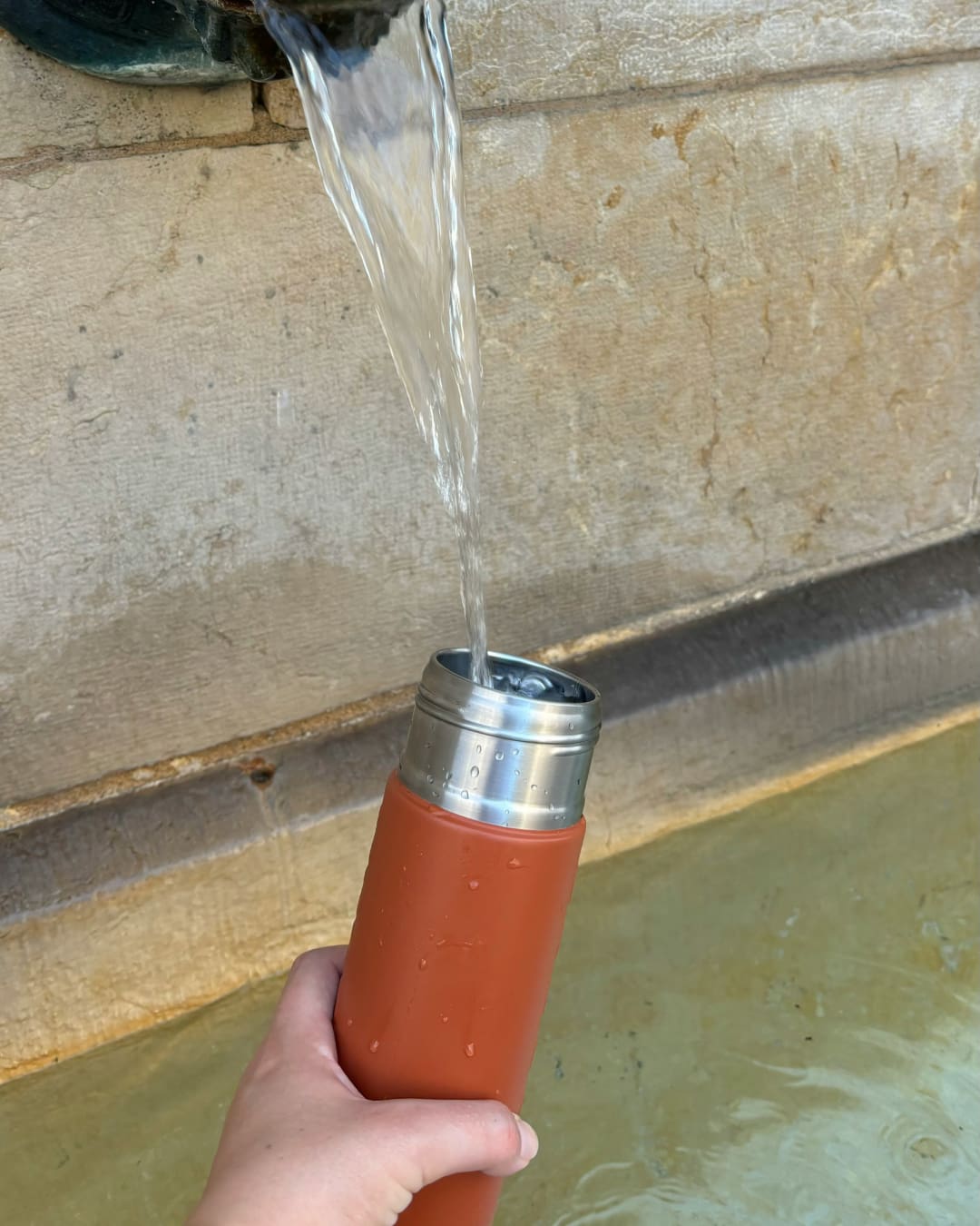 Person refilling water bottle in Geneva Switzerland