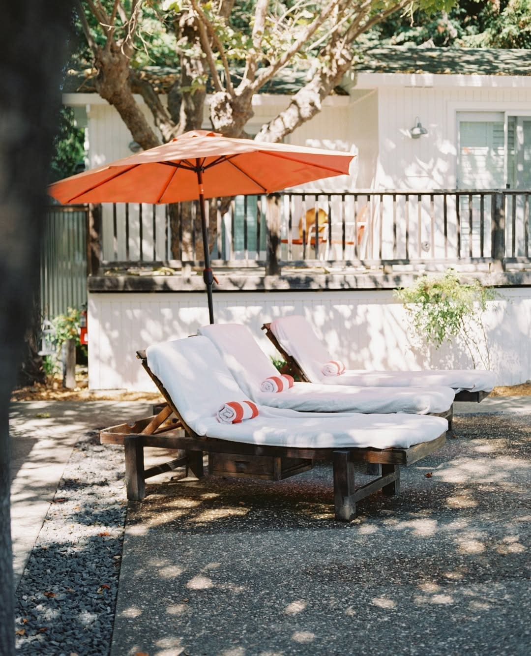 Two sun loungers beneath an orange parasol at Boon hotel + spa