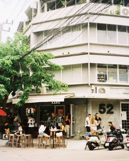 Exterior of Karo, a coffee shop in Bangkok with people enjoying coffee outside