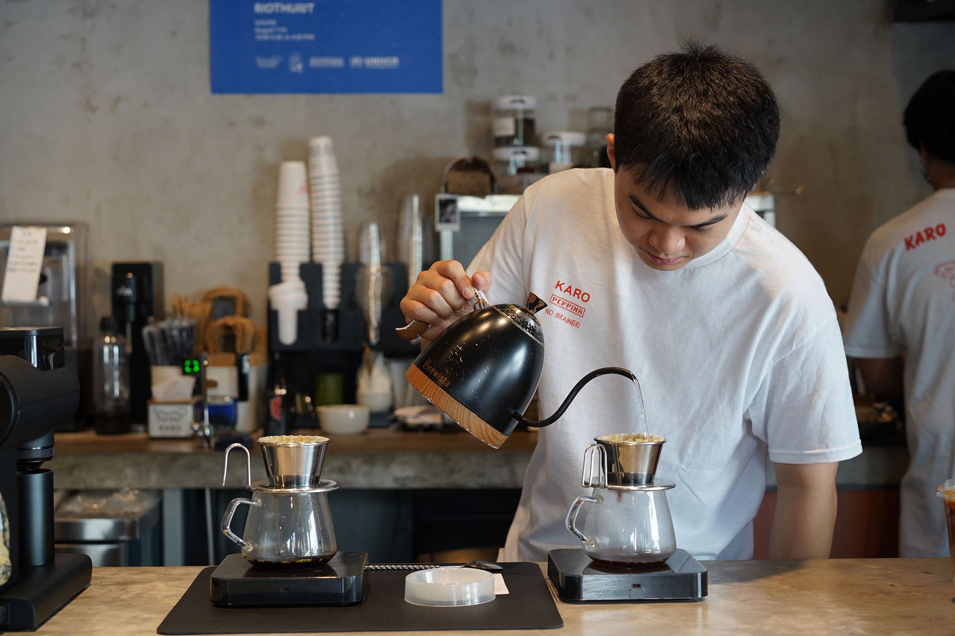 A barista prepares a batch of pour over coffee for a customer at Karo in Bangkok