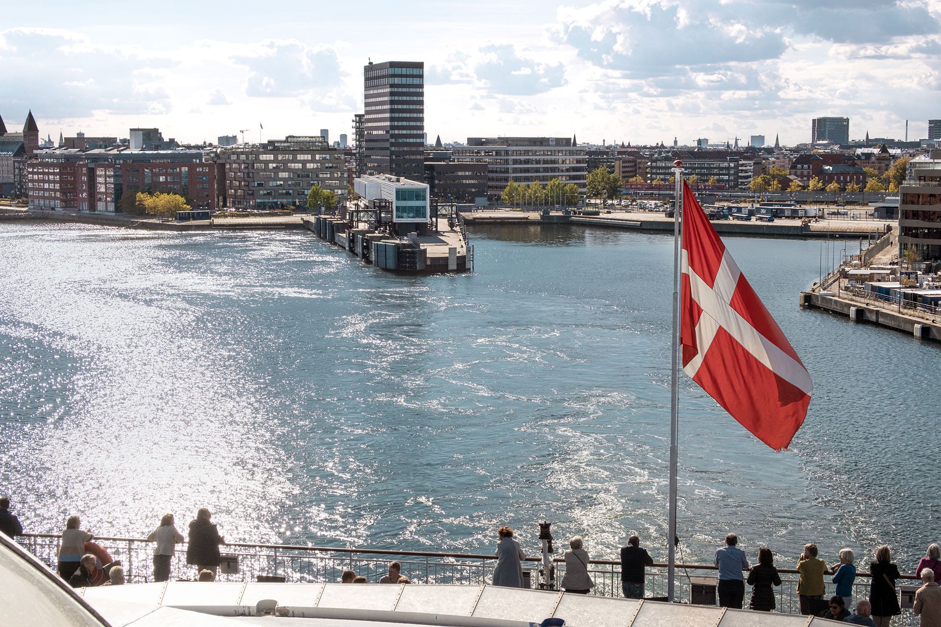 Passengers aboard the Oslo to Copenhagen ferry stand and look at Oslo during the departure