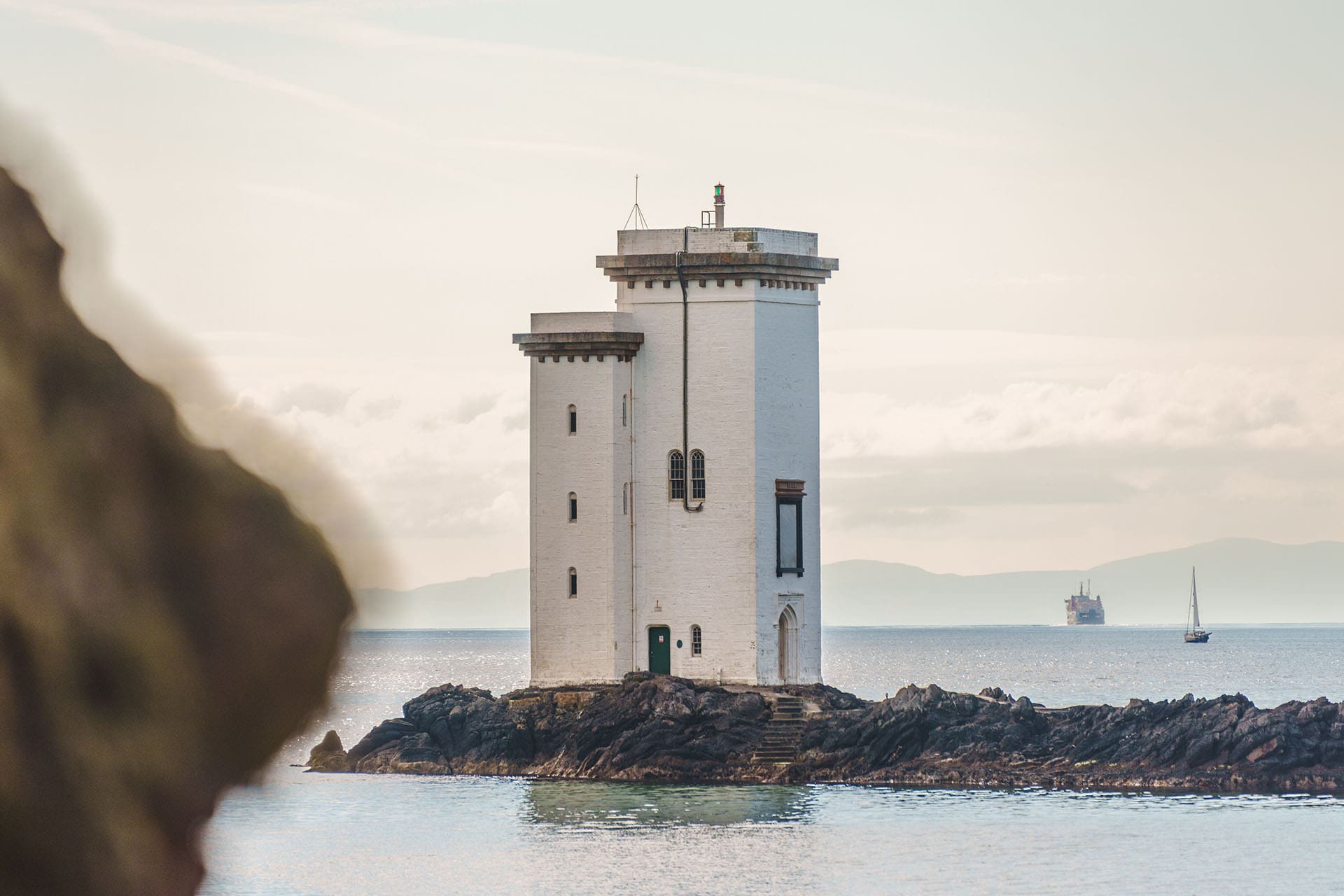 Carriag Fhada Lighthouse with boats in distant background