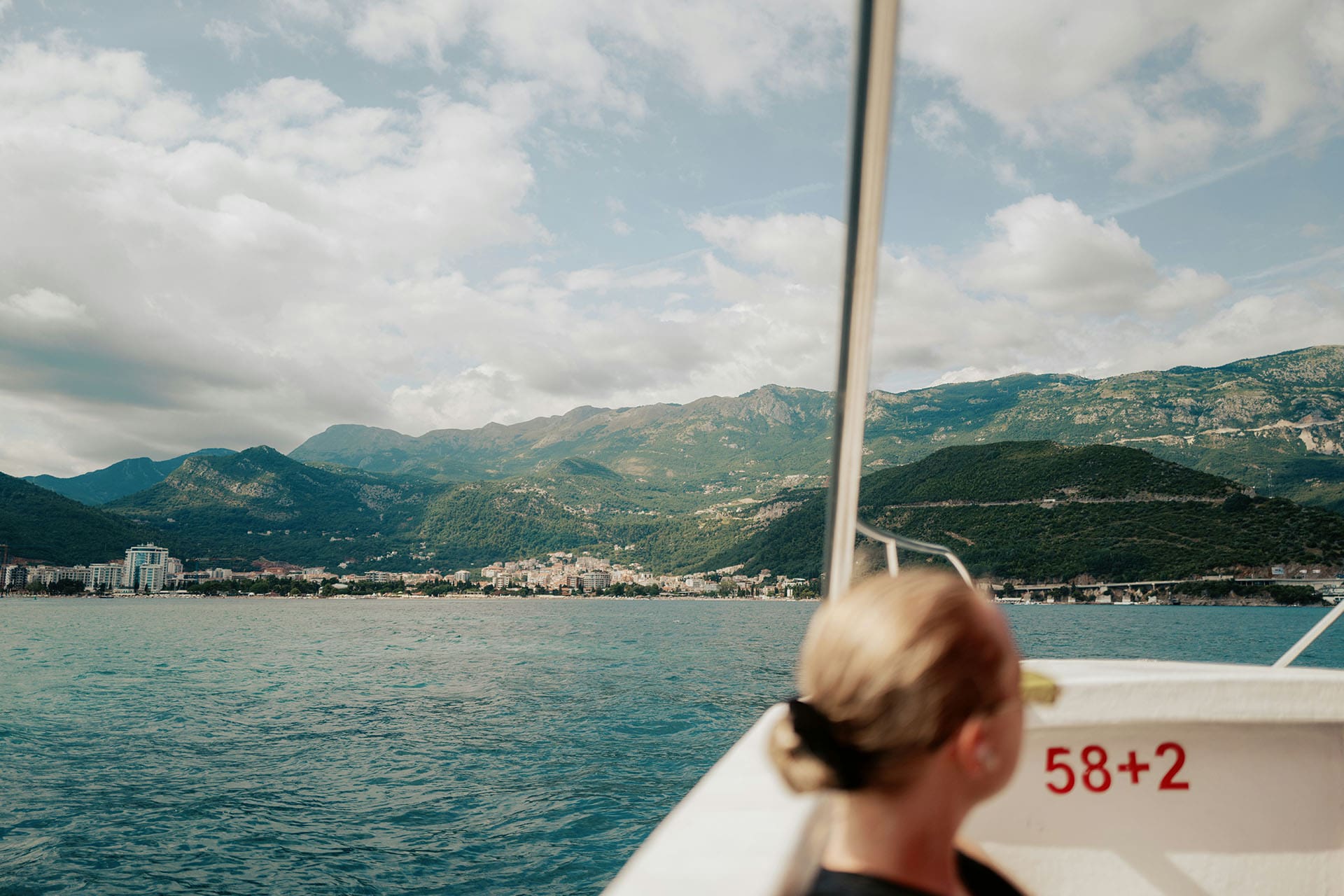 A woman, out of focus, enjoys a scenic ferry ride along the Dalmatian coast in Croatia