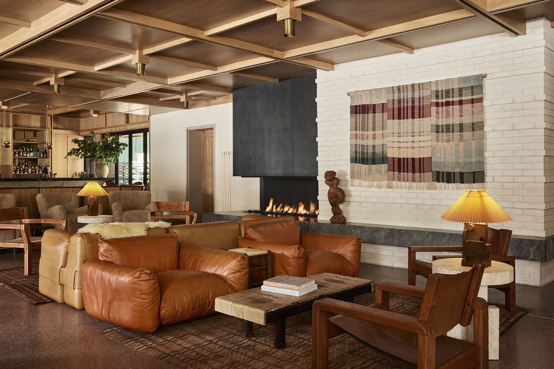 Central room at Mollie, warm interior with considered furniture and fire