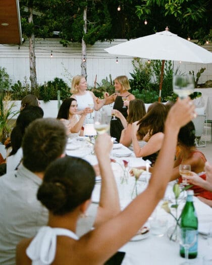 An outdoor scene in a garden with guests enjoying a supper club, hosted by Chloe Walsh