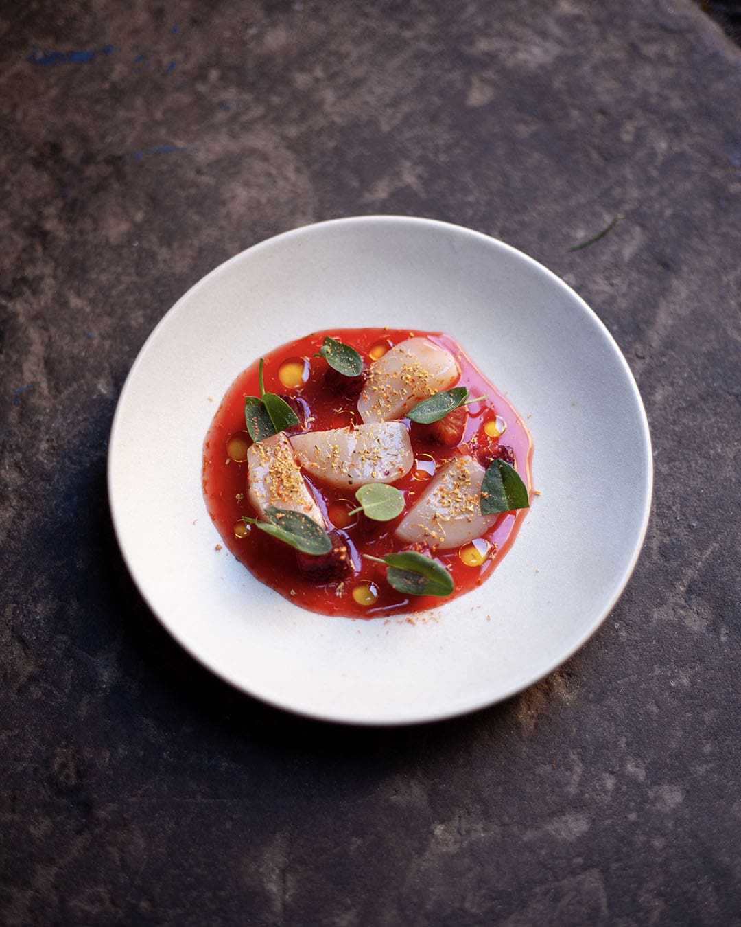 A dish of freshly prepared food on modern white china plate on a slate background