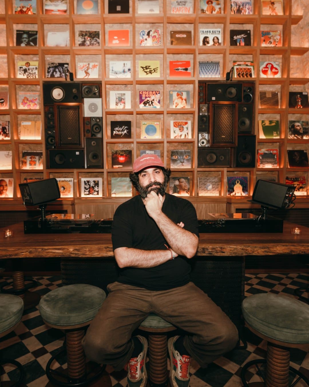 A man sat in front of a wall of vinyl at Drop Sociale bar in Beirut