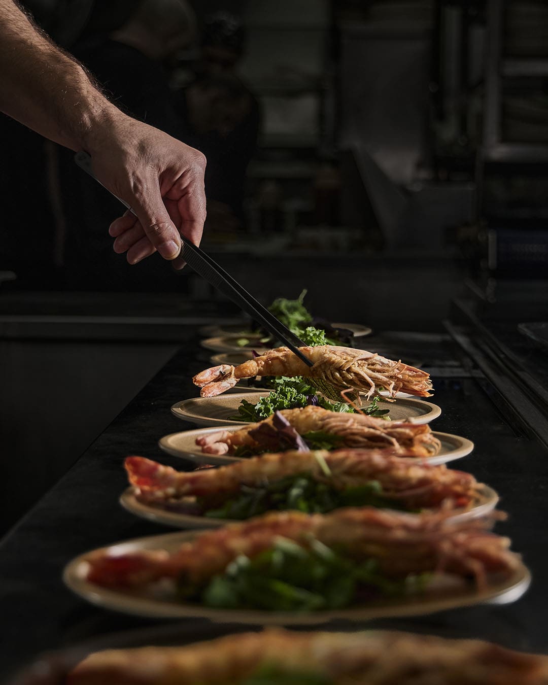 A hand prepares seafood at Le Canoë in Beirut