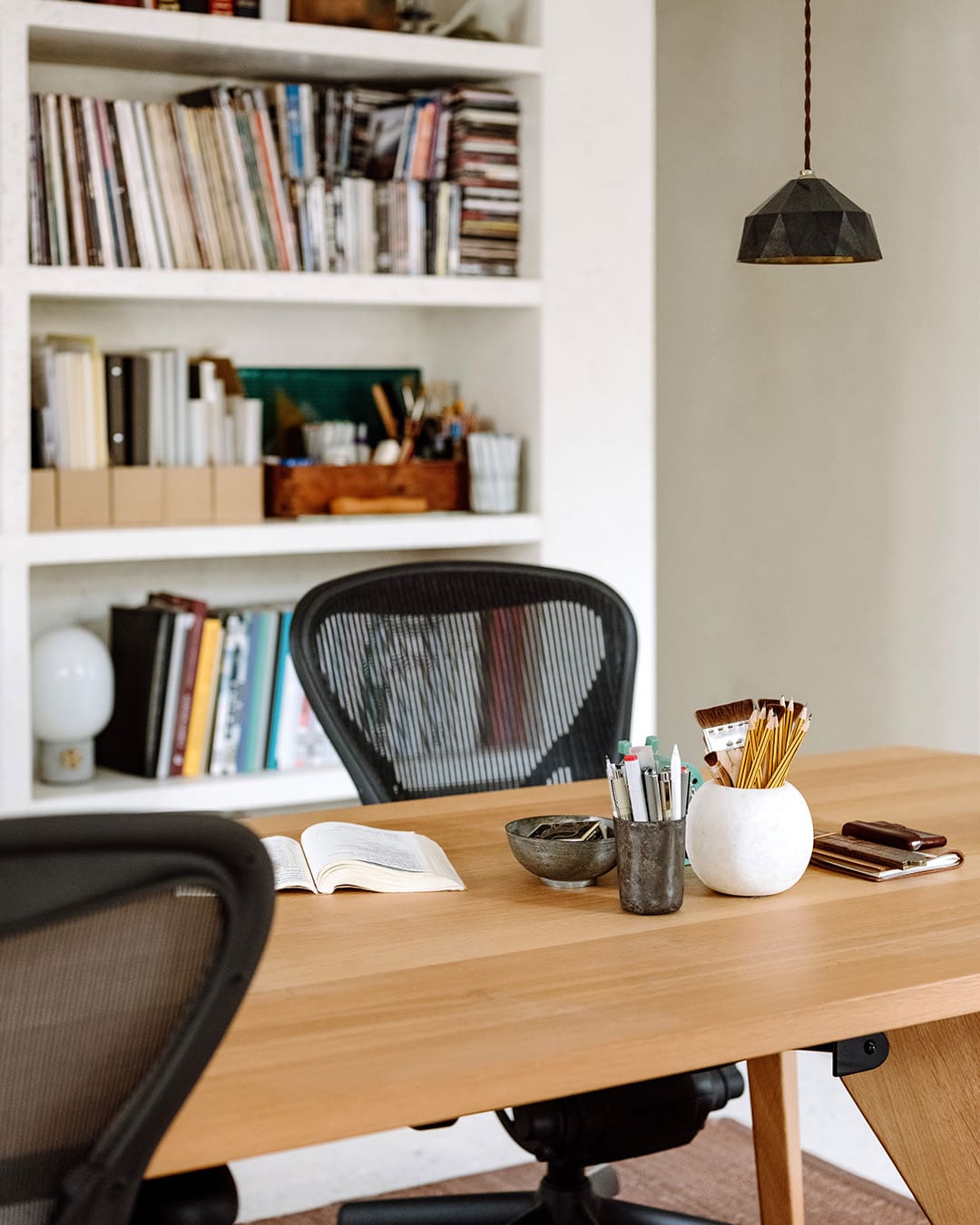 Wooden table with modern office furniture and bookshelf