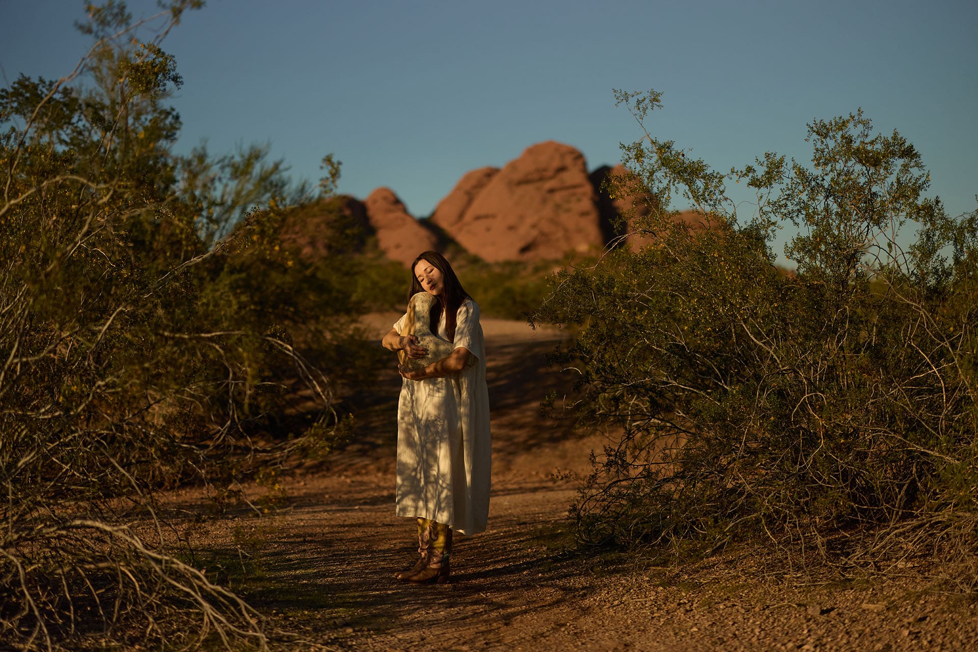 Rika Kova holding one of her clay pieces in the Sonoran Desert. Photography by Matt Martian