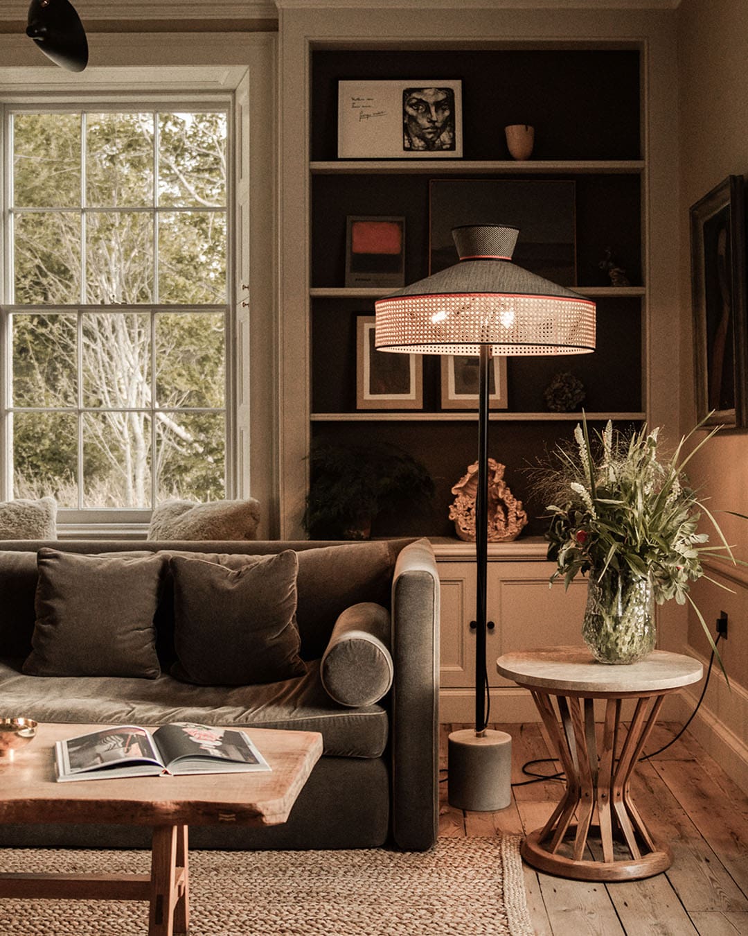 Corner of a confortable lounge with sofa and sidelights and window view outside into the Scottish wilderness