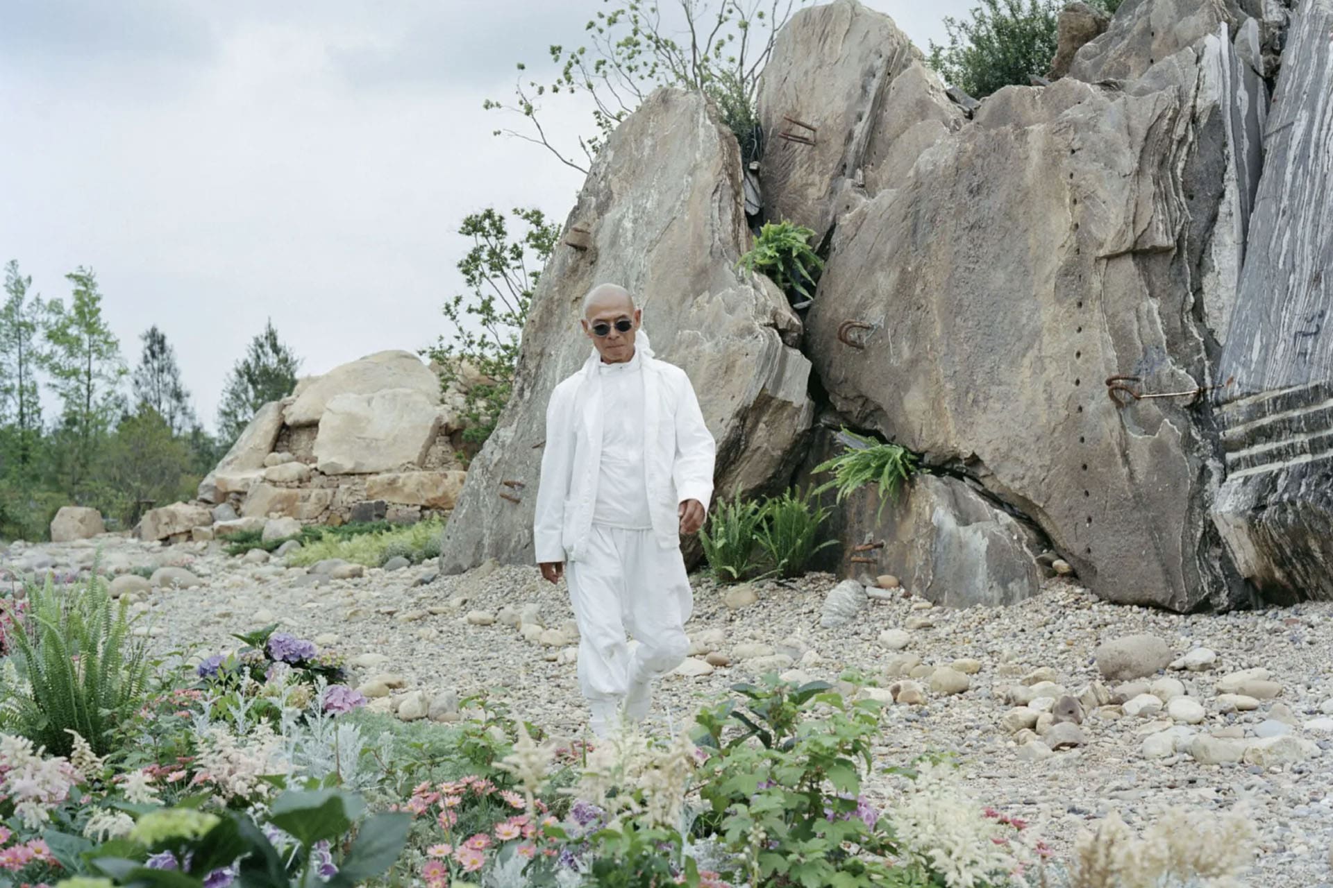 Chinese artist Zhang Huan standing in his Shanghai garden