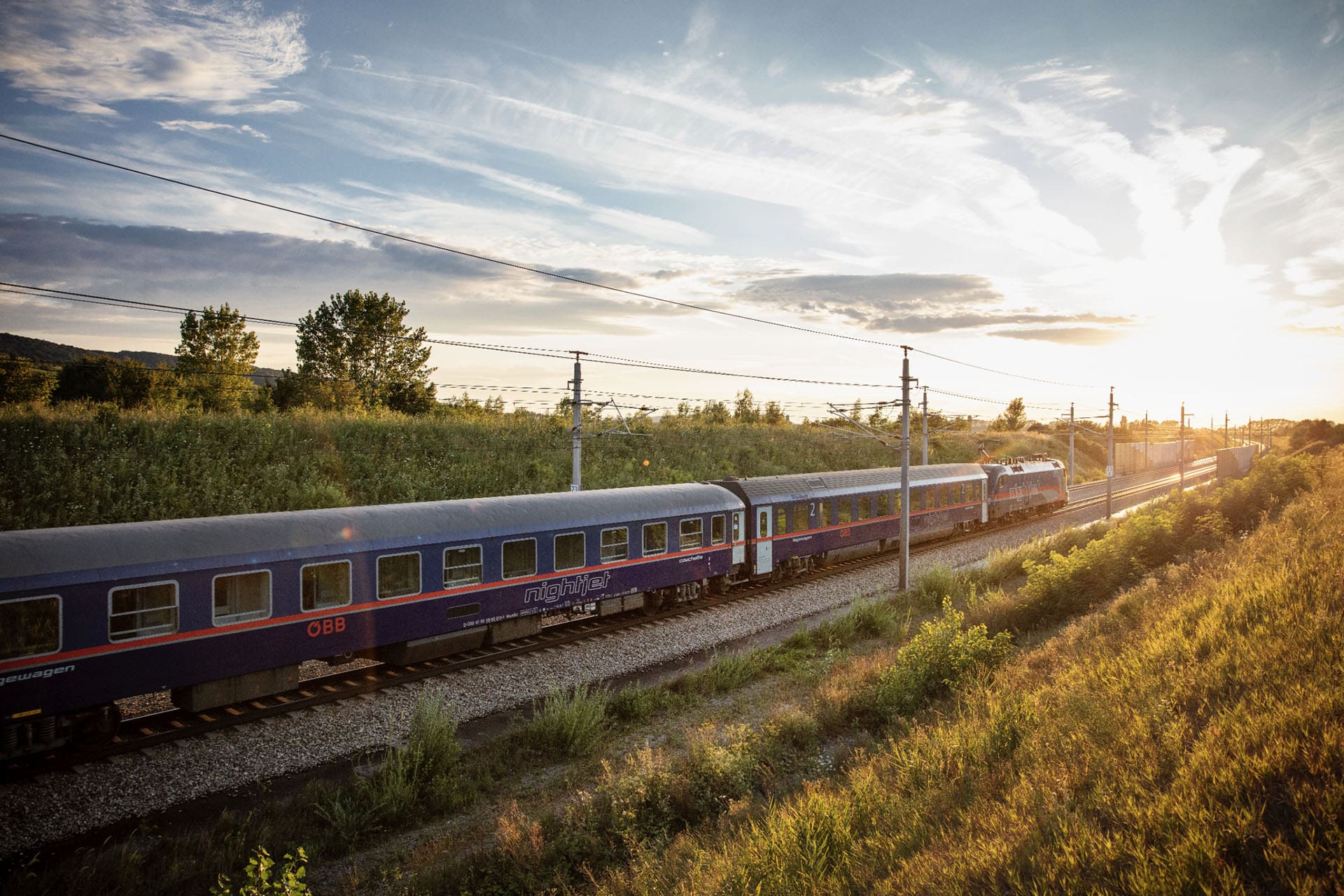 The return of European sleeper trains | The ÖBB Nightjet travelling through a green field at sunset