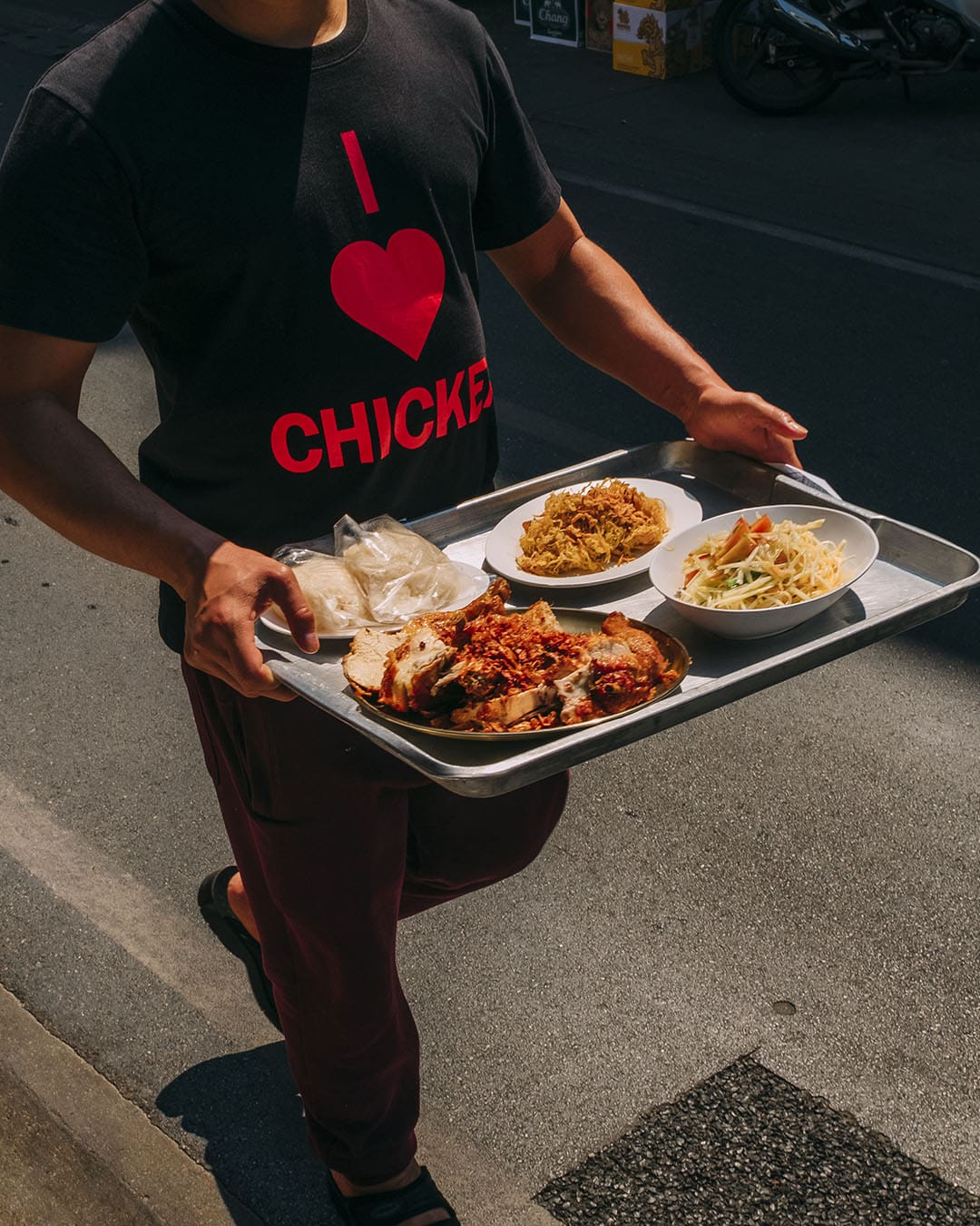 A person wearing a T-Shrt that says I Love (Heart) Chicken serves up their renowed Fried Chicken