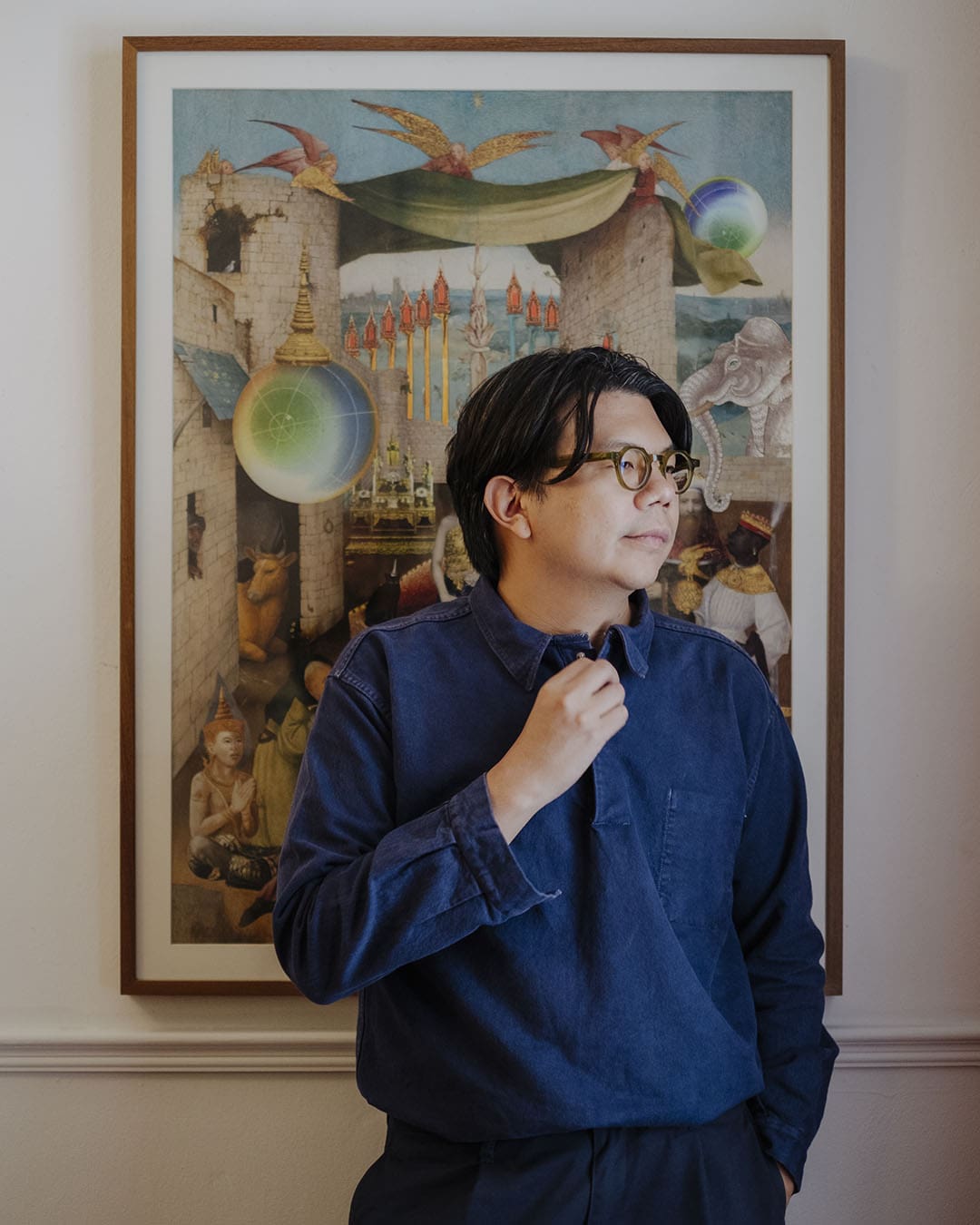 The artist Nakrob Moonmanas stands in front of one of his artworks at his studio.