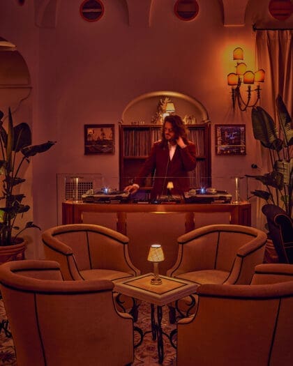 A well dressed DJ plays records in a peaceful surrounding