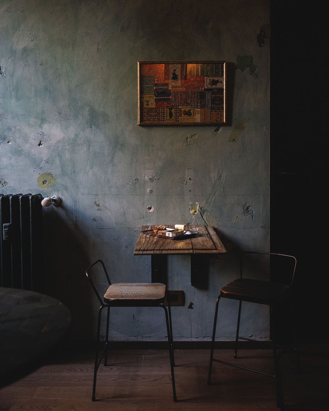 A table by a grey wall at Norah Was Drunk in Milan. Photography by Jacopo Salvi