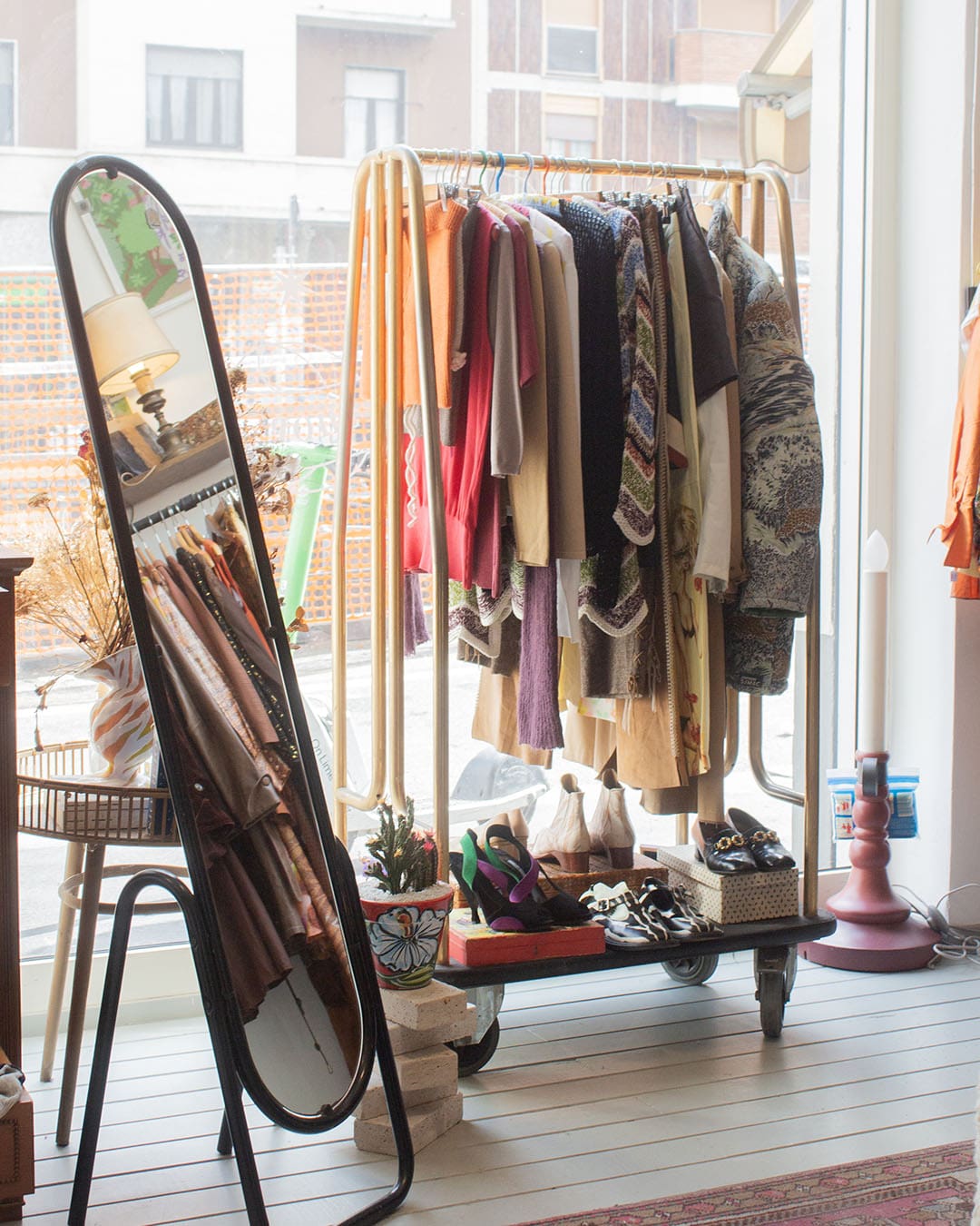 Clothes and vintage fashion displayed on a rack in the window of Sous Vintage in Milan