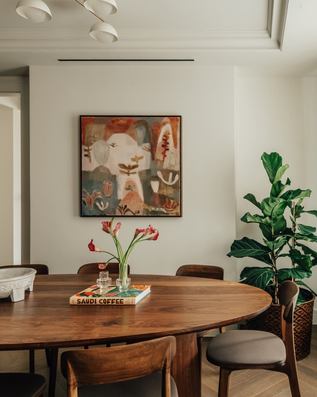 An oak dining table by a painting at Claridge House by SLO, London