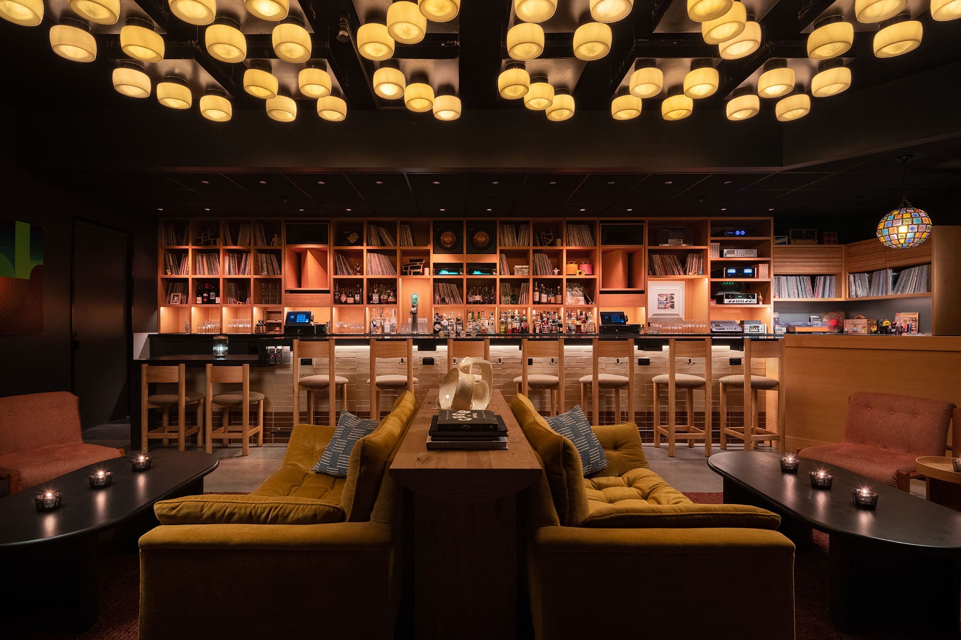 A comfortable seating area with couches for listening to music. Records and a bar are in the background