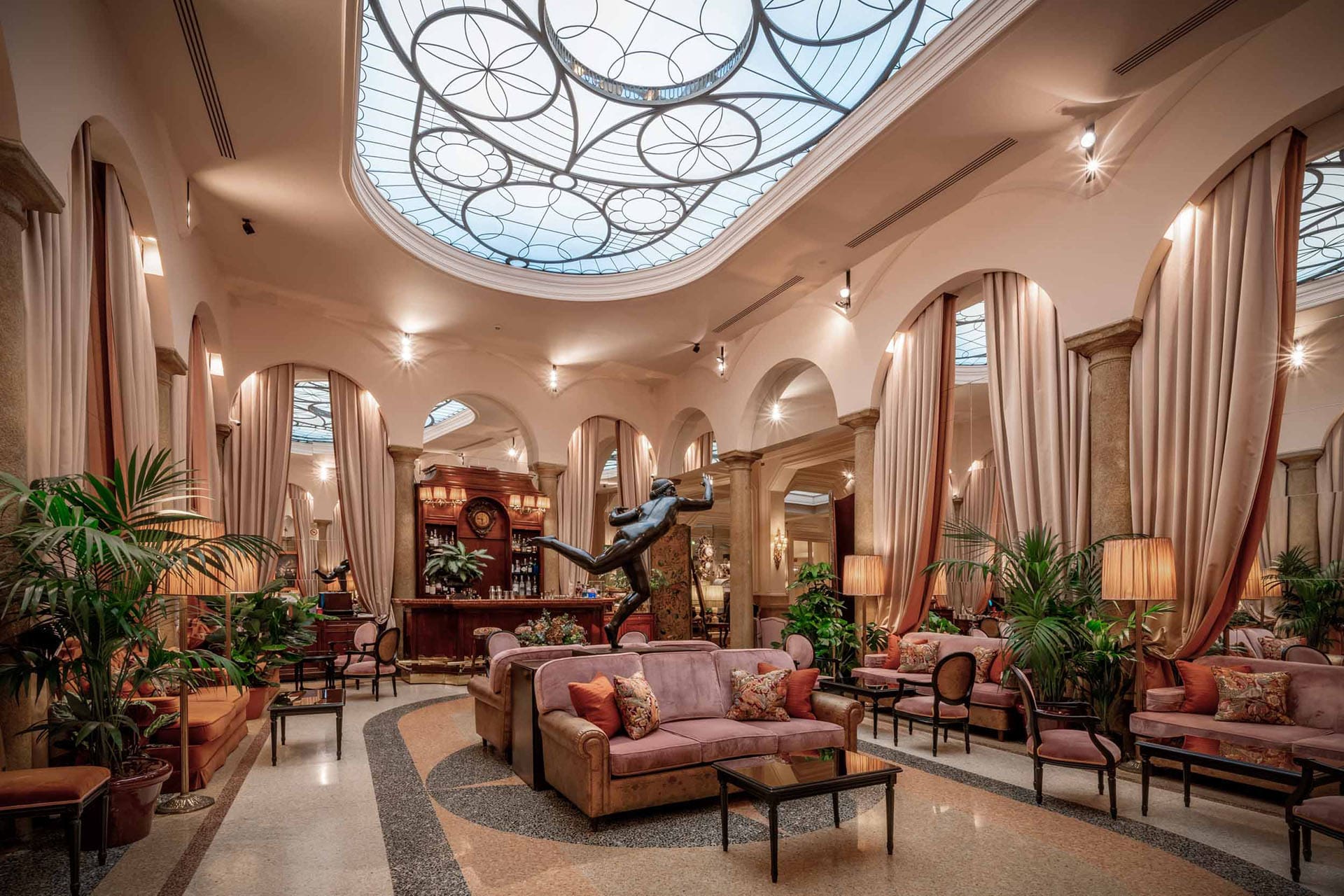 Grand interiors at Grand Hotel et de Milan with a central statue