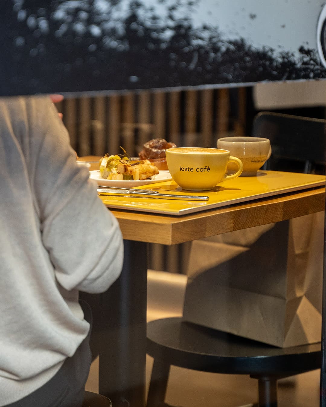 Customer sits in a coffee shop in Milan enjoying coffee and pastries
