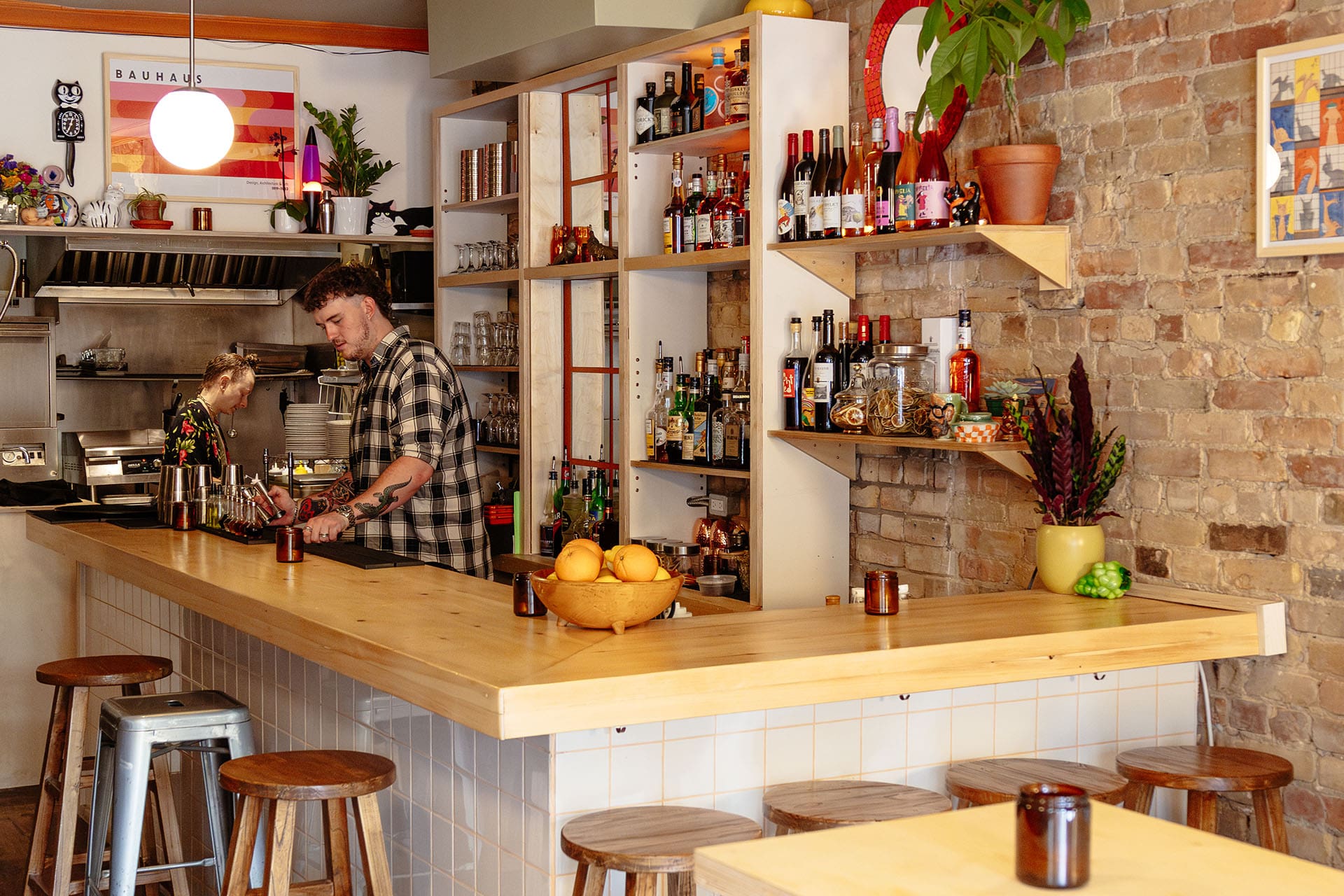 Modern light bar area with seating and bartenders prepare the drinks