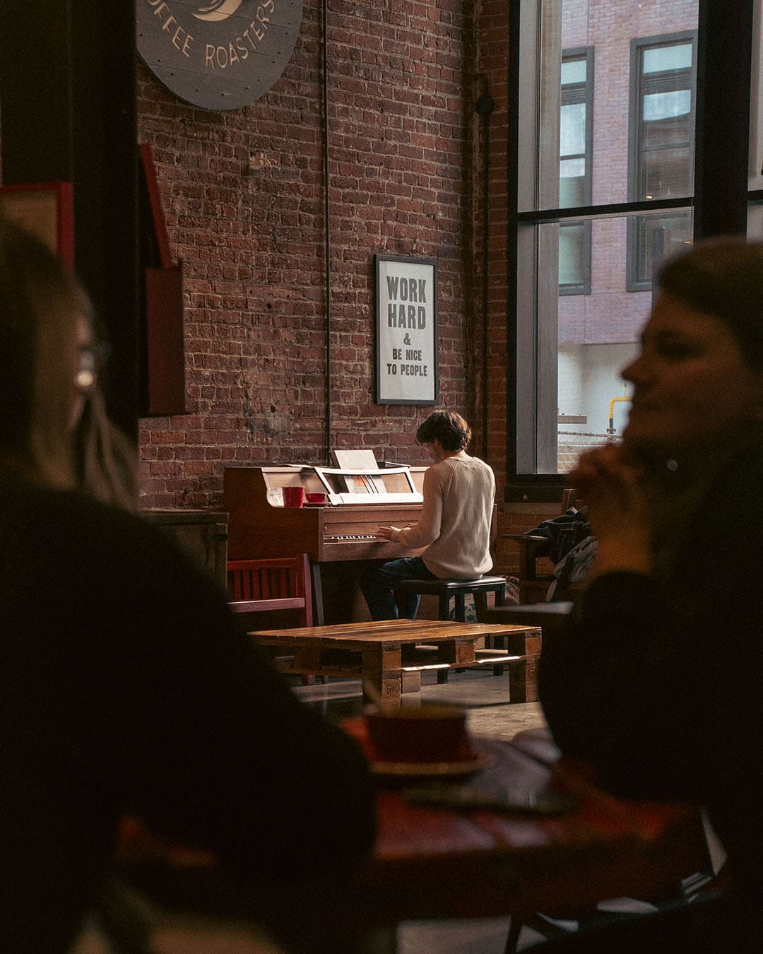 A man plays the piano in a modern coffee shop in Toronto called Ethica