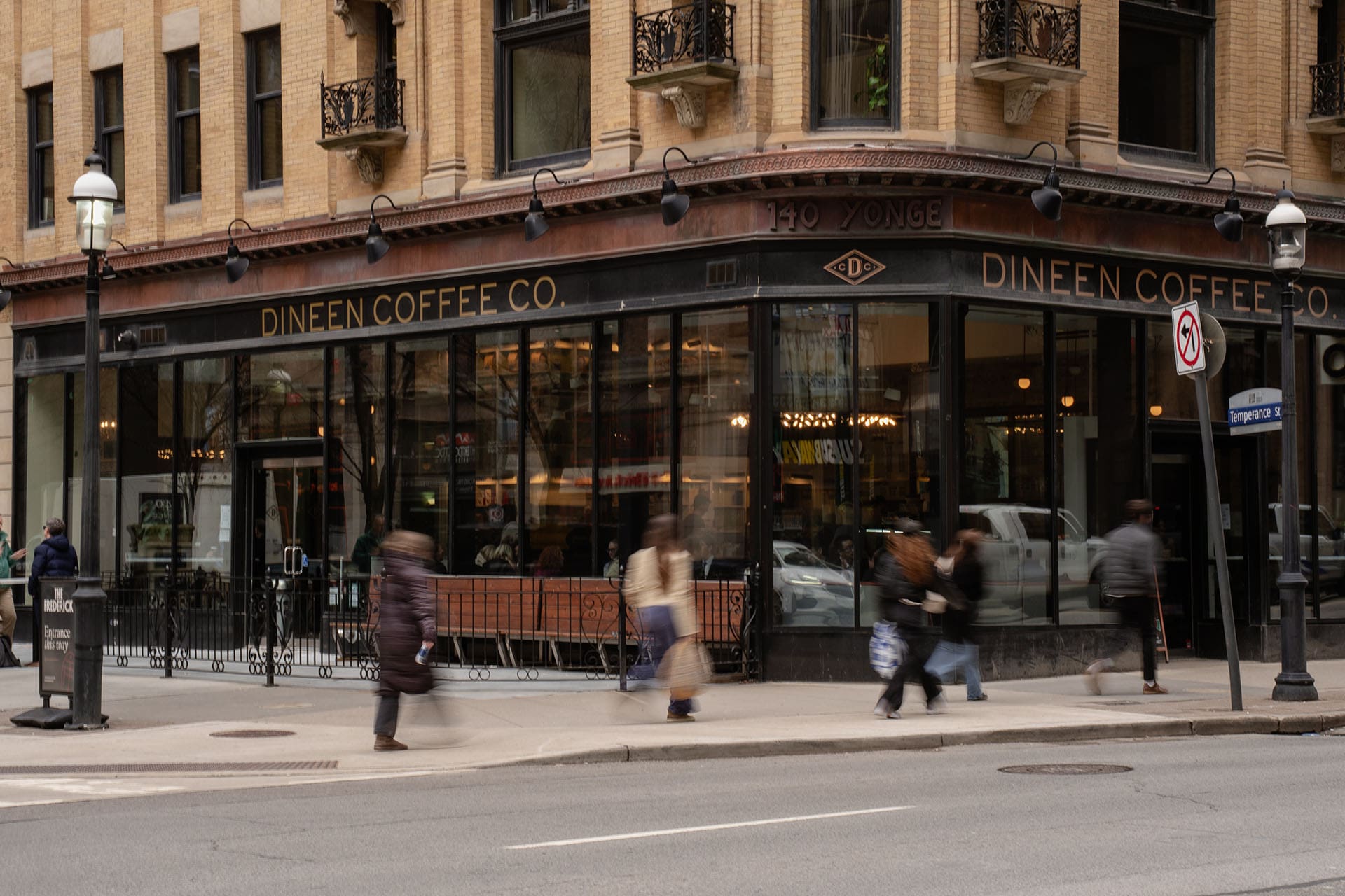 People walk by the exterior of Dineen's Yonge Street branch, a noted coffee shop in Toronto