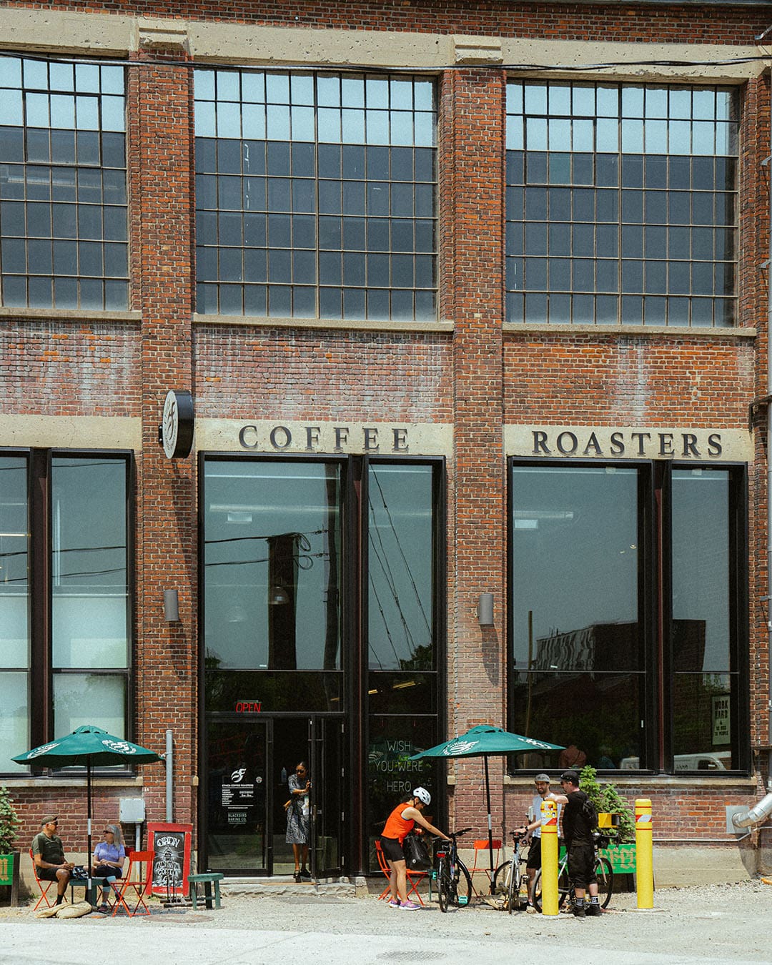 The brick exterior of Ethica with customers enjoying coffee