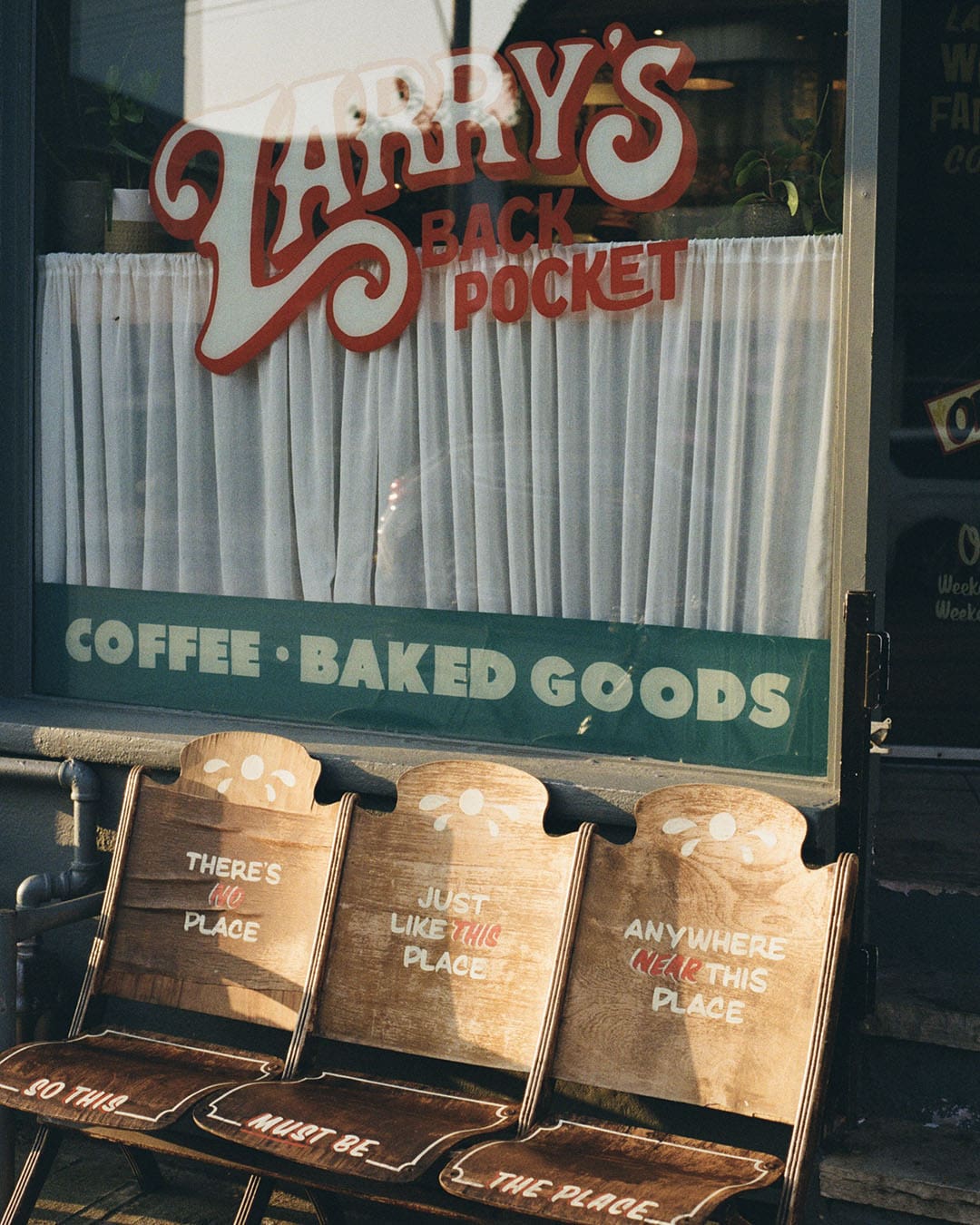 A retro style image of a Toronto coffee shop called Larry's Back Pocket. Seats out front with signage on the window