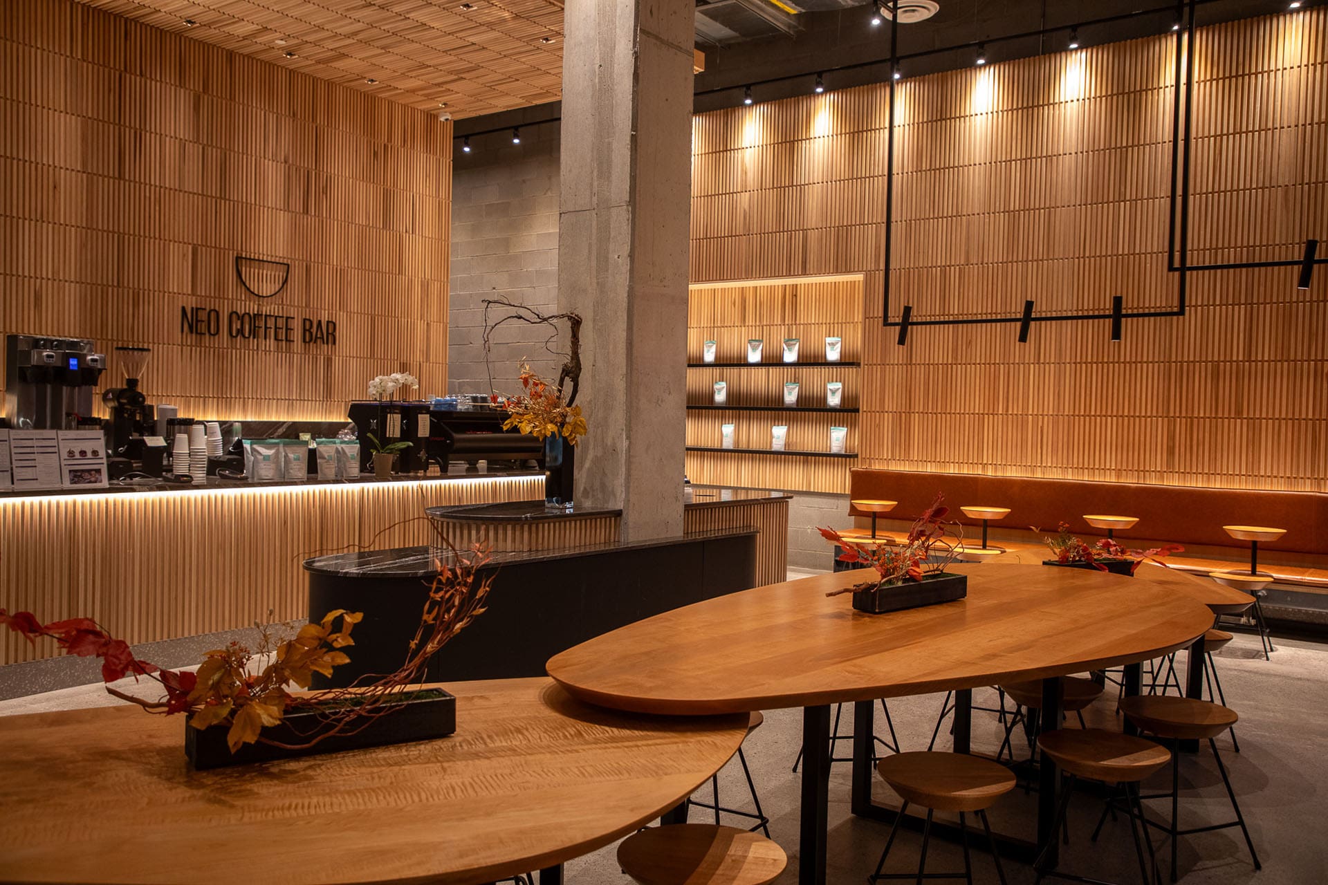 Two large tables in a modern wooden interior of the Neo coffee shop in Toronto