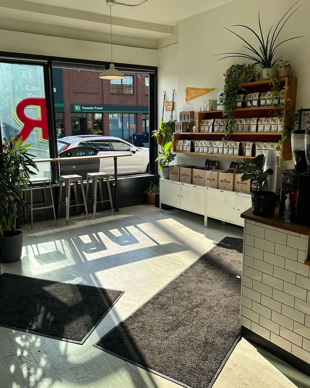 Interior of Reunion coffee shop in Toronto, looking out to the street with the counter and coffee merchandise