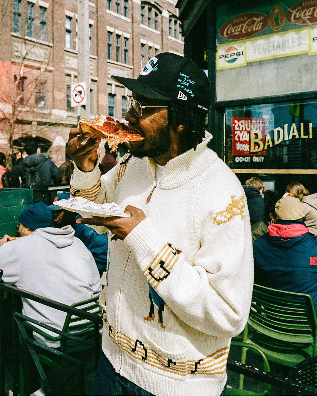 A patron enjoying a slice of Pizzeria Badiali's finest in the street