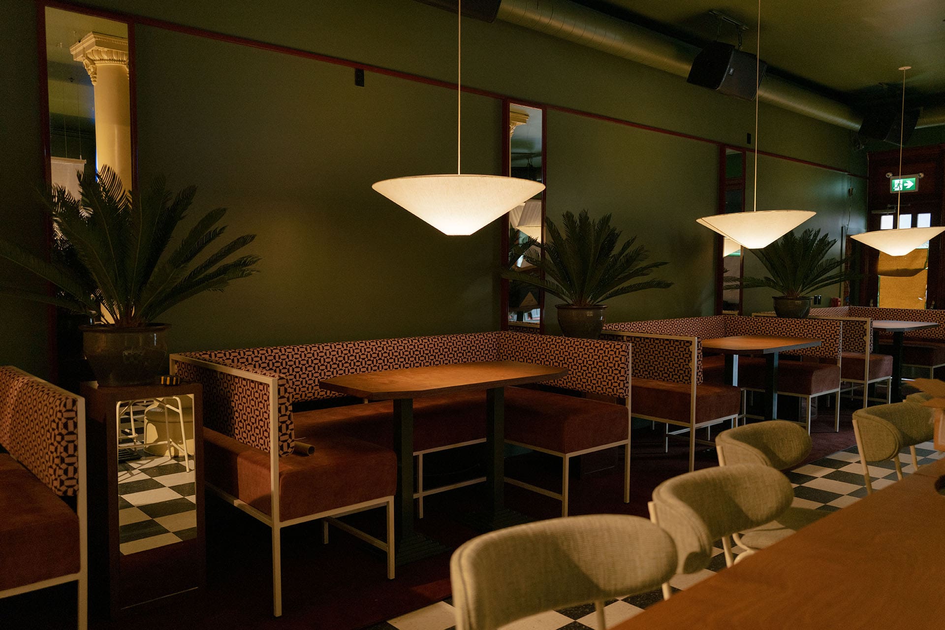 Tables and chairs in a bar seating area with warm atmospheric lighting
