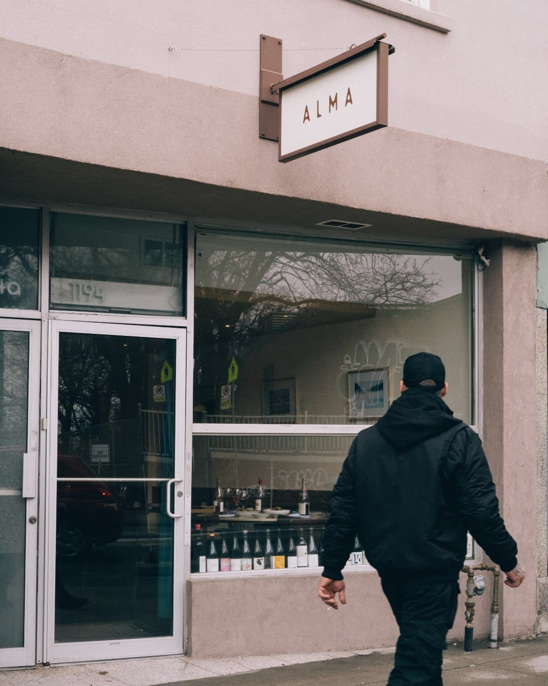 The exterior of Alma in Toronto with a man walking by